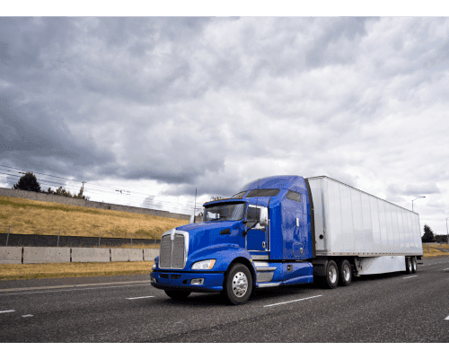 Picture of a blue truck pulling a dry van trailer